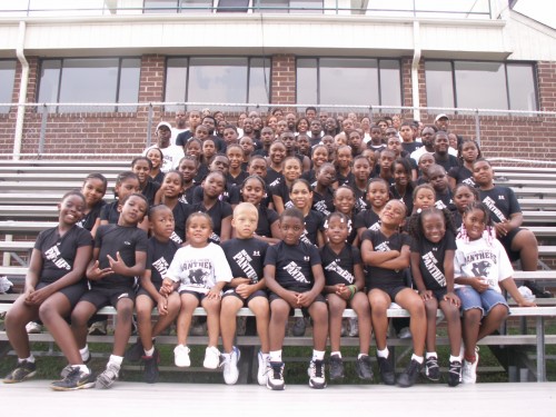 Panthers Elite Track & Field Club youth team group photo outside building.