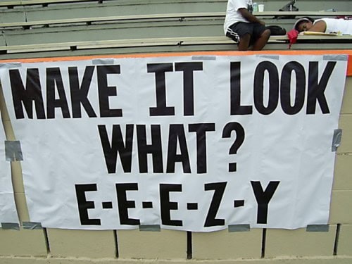 Banner with the phrase "Make it look what? E-E-E-Z-Y" at a track event.
