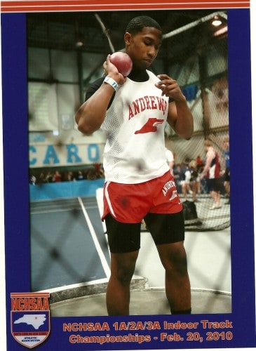 Young male athlete preparing for shot put at indoor track championships.
