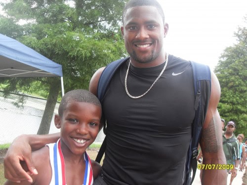 Happy young athlete with coach at Panthers Elite Track & Field event.