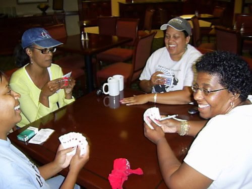Group of women enjoying a card game at a table in a casual indoor setting.