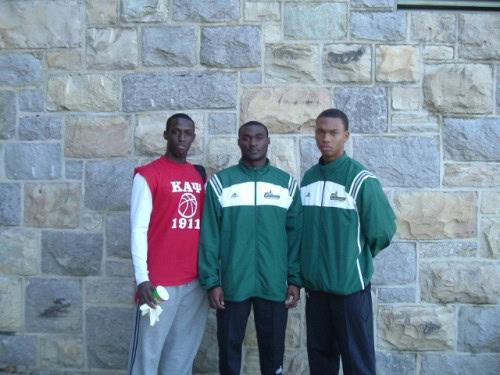 Kappa track athletes standing outdoors against a stone wall.
