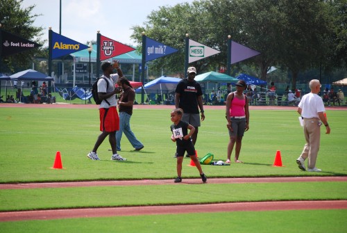 Running young athlete participating in track event at Panthers Elite Track & Field Club meet.