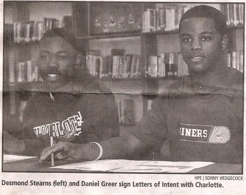 A detailed image of Desmond Stearns and Daniel Greer signing letters of intent with Charlotte, celeb.