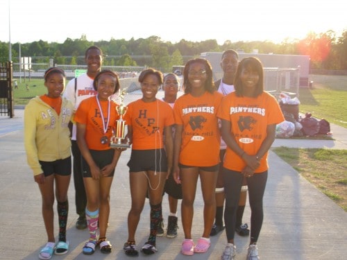 Panthers Elite Track & Field team celebrating outdoors at sunset.
