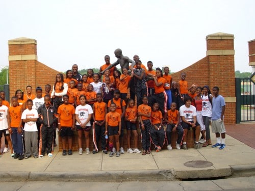 Group of young athletes in orange and white uniforms at Panthers Elite Track & Field Club.