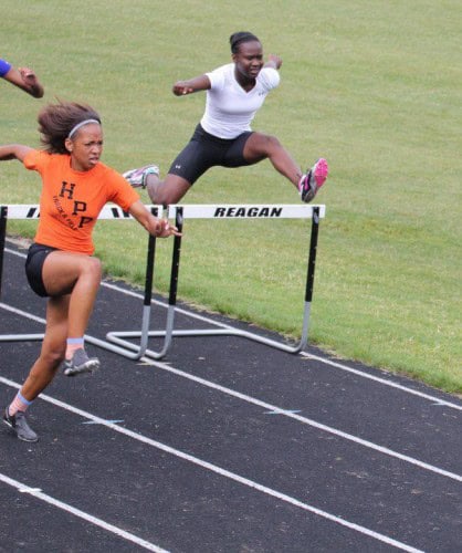 Hurdler clearing a hurdle during a track and field race at Panthers Elite Track & Field Club.