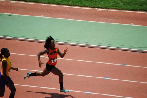 Female sprinter running on a track during a race at Panthers Elite Track & Field Club.