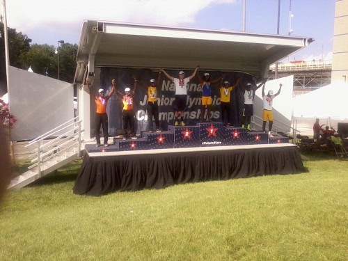 Panthers Elite Track & Field athletes celebrating on stage at awards event.