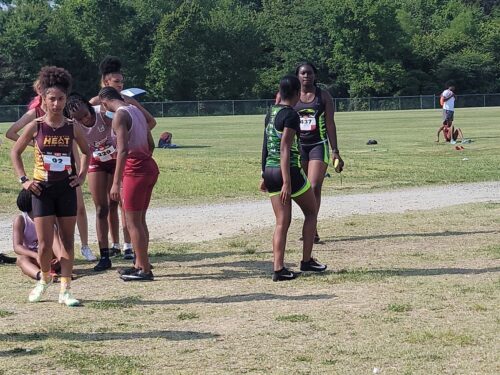 Young track athletes warming up on the field before a race at Panthers Elite Track & Field Club.