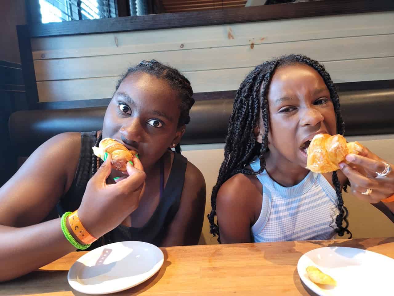 Two young girls enjoying burgers at Panthers Elite Track & Field event.