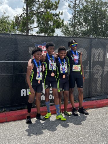 Young athletes from Panthers Elite Track & Field team celebrating with medals.