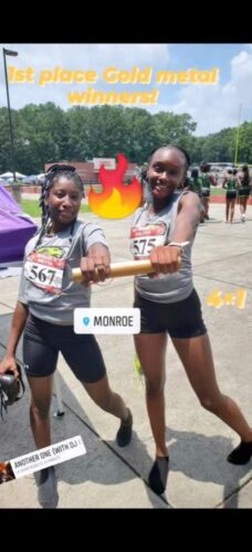 Young athletes celebrating gold medal win at meet.
