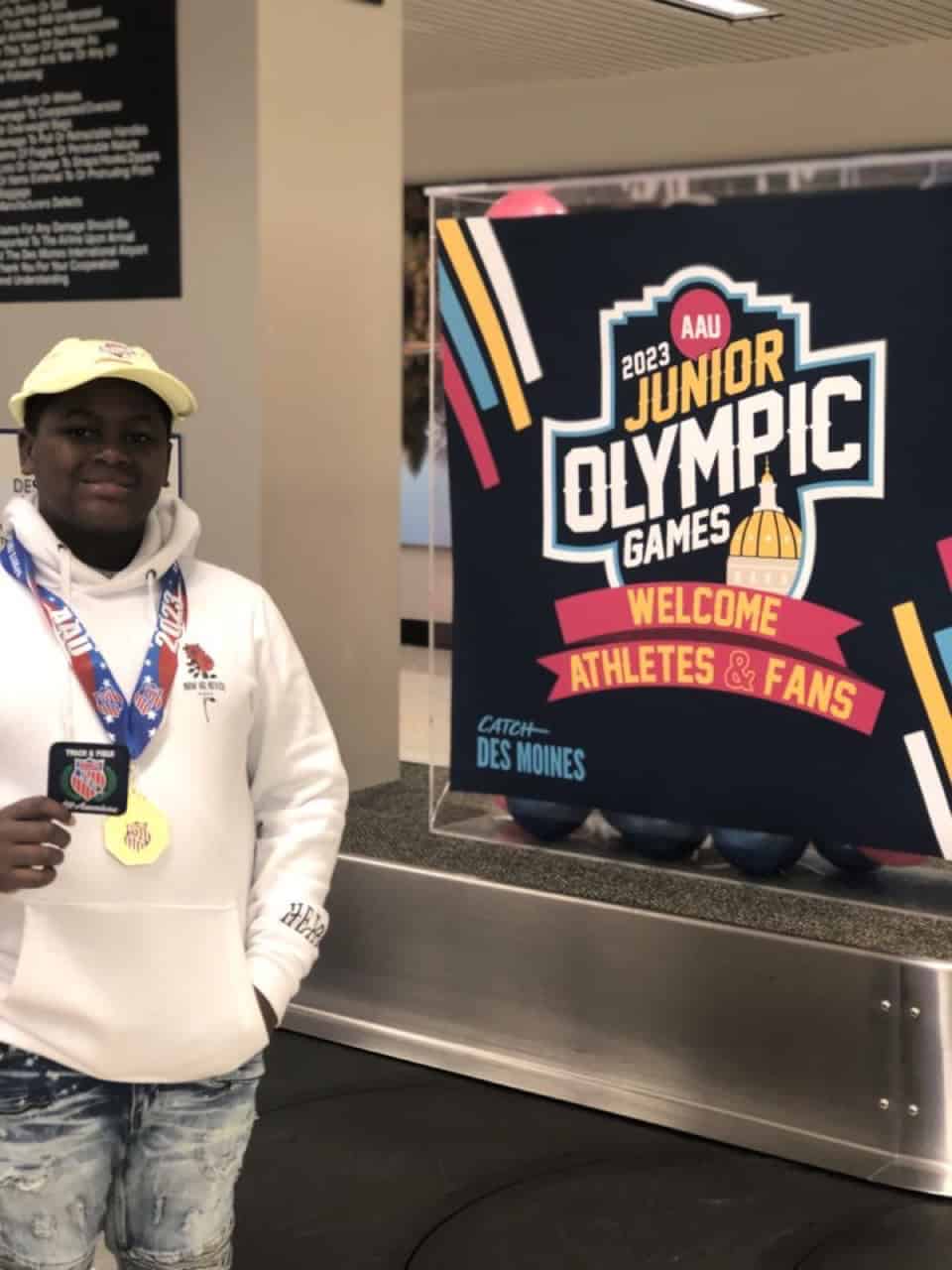 Young athlete holding medal at Junior Olympic Games 2023.