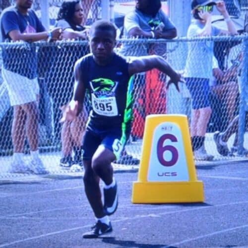 Young athlete sprinting on track during a race at Panthers Elite Track & Field Club event.