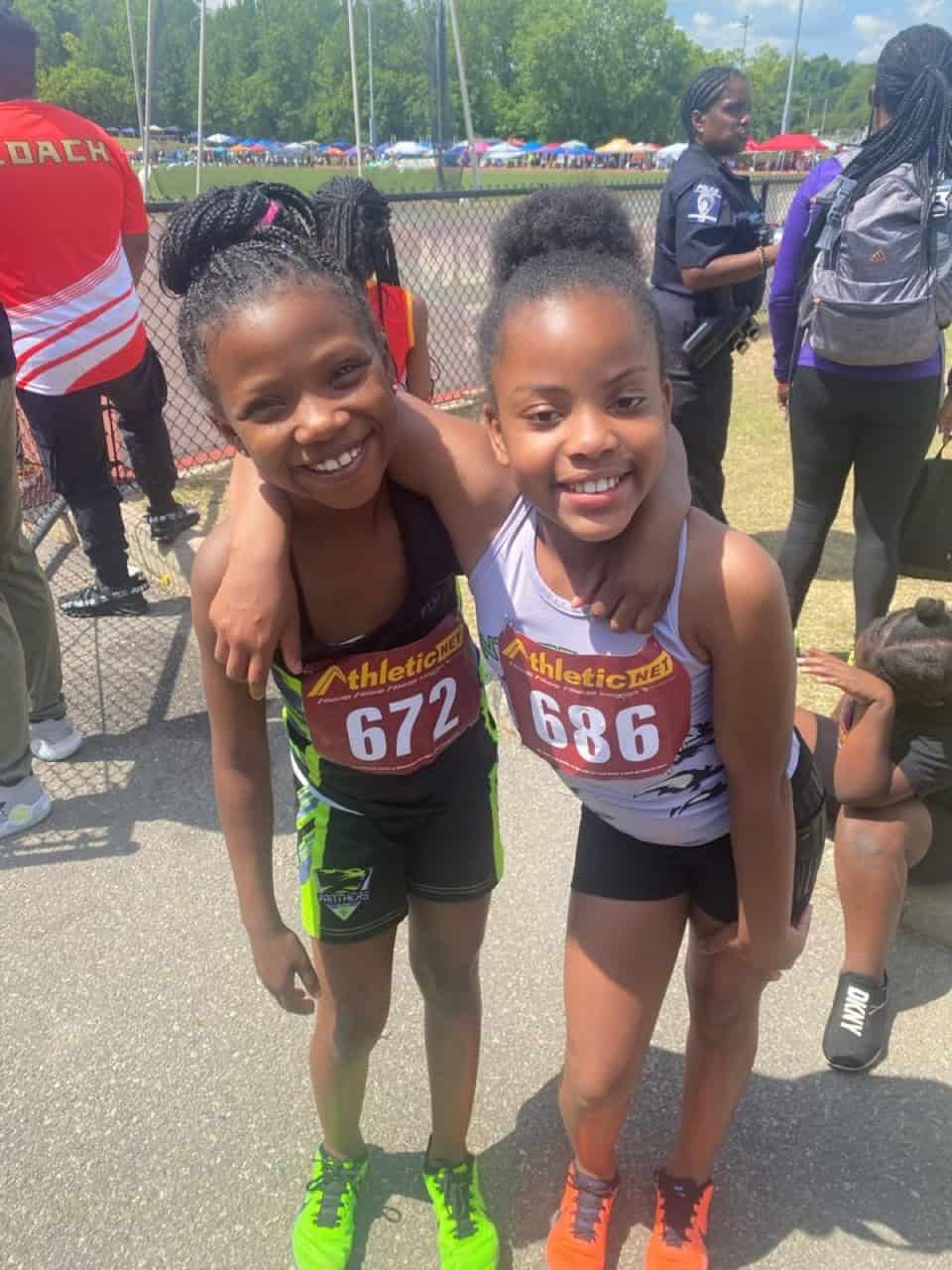 Young female athletes smiling at a track meet.