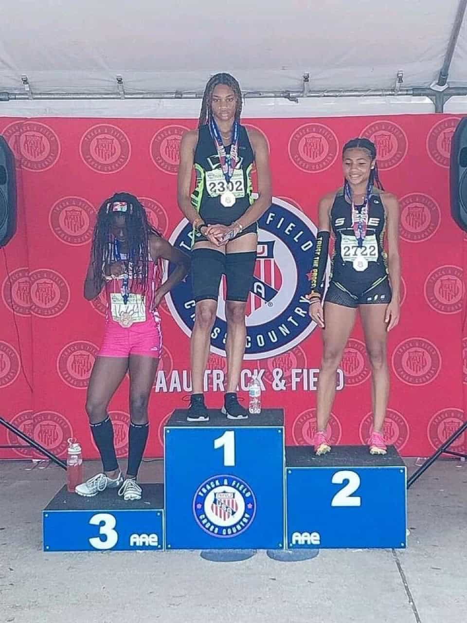 Athletes on the winners' podium at a track event, celebrating their achievements.