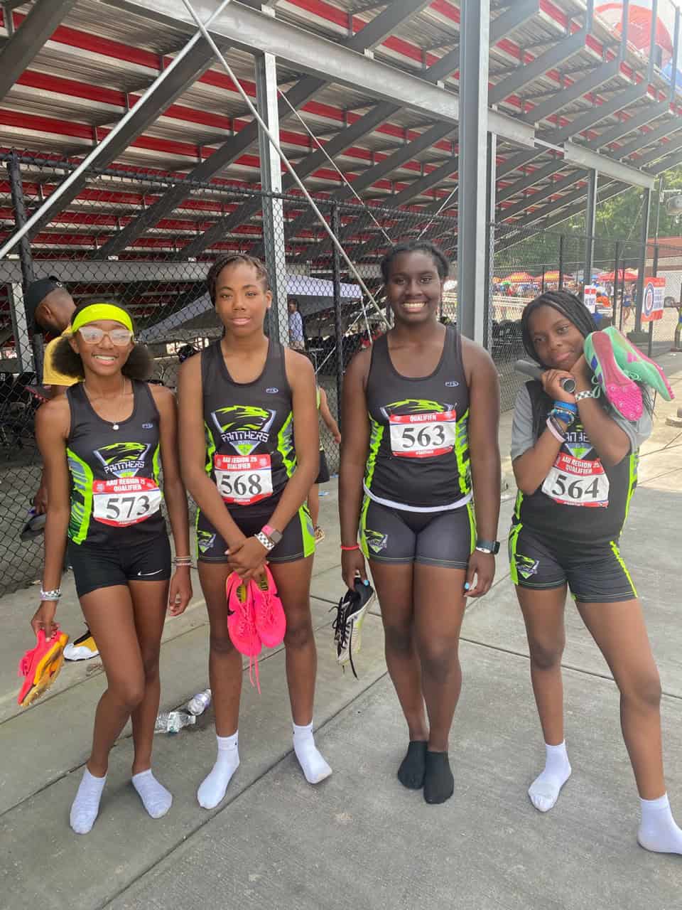 Group of young female track athletes at a meet.