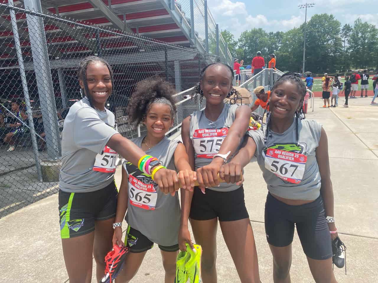 Group of young female athletes from Panthers Elite Track & Field Club smiling after a race.