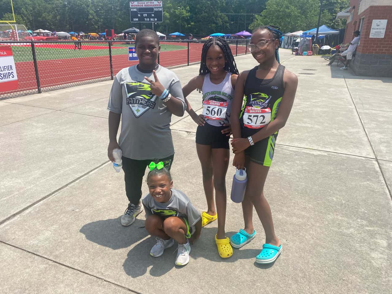 Panthers Elite athletes at a track meet, smiling and ready to compete.