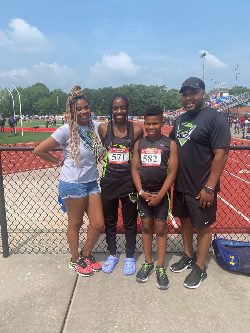 Young athletes with coach at track meet.