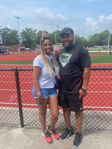 Panthers athlete with coach at track meet.