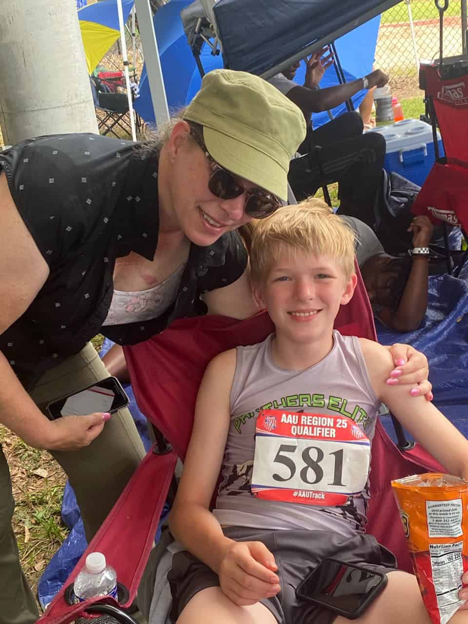 Young athlete with coach at track meet.