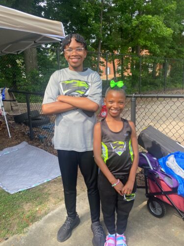 Young athletes smiling at outdoor event.