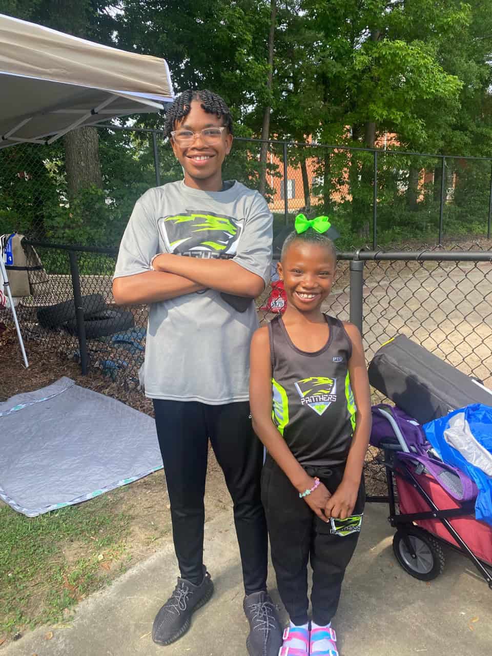 Young athletes smiling at outdoor event.