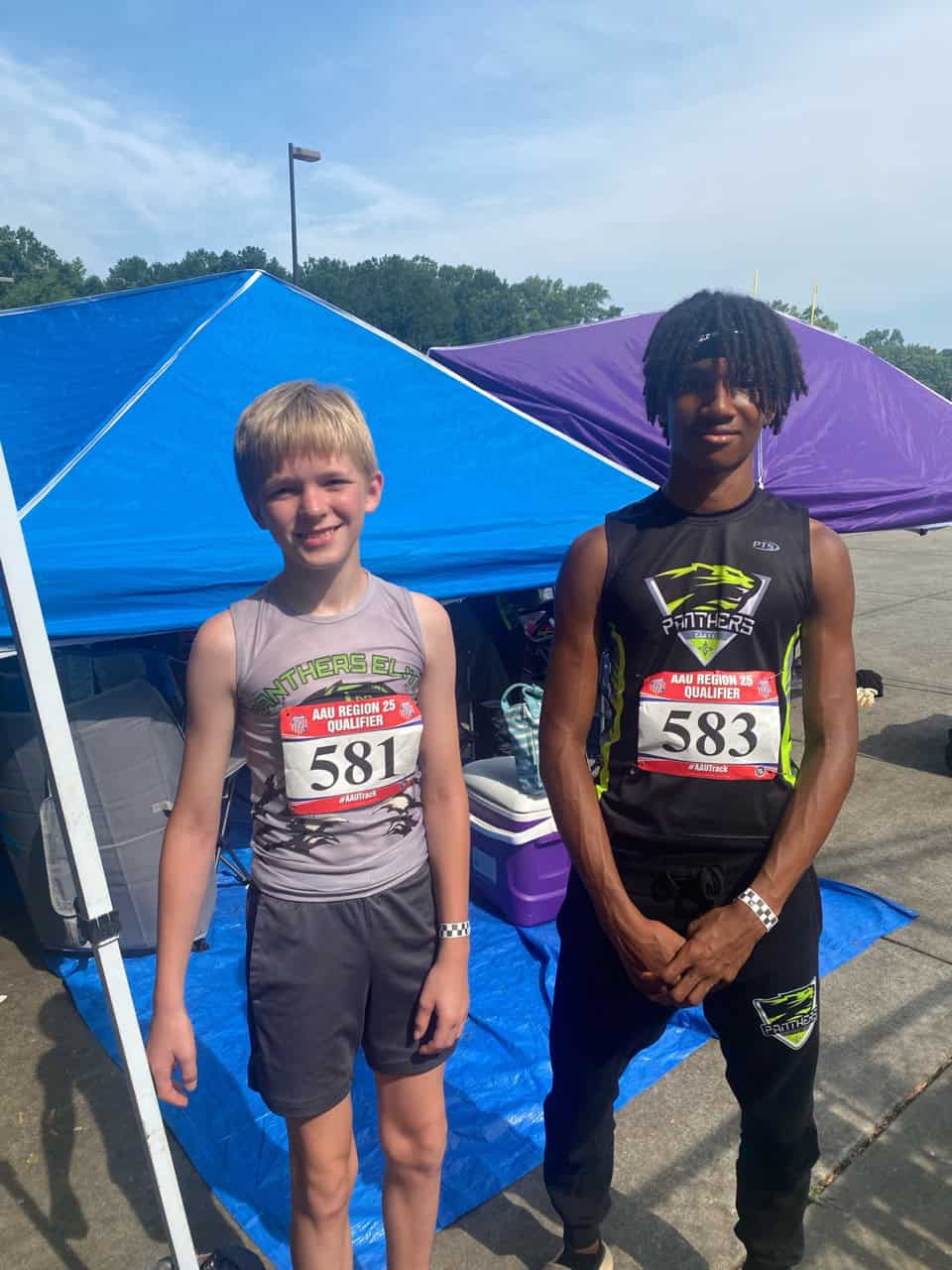 Athletes at Panthers Elite Track & Field Club posing outdoors with tents, showcasing team spirit and.