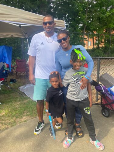Family photo of Panthers Elite Track & Field members outdoors.