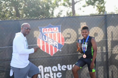 Coach and athlete celebrating at Panthers Elite Track & Field event.