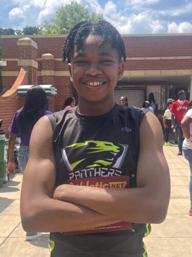 Panthers Elite Track & Field athlete smiling outdoors at a track event.