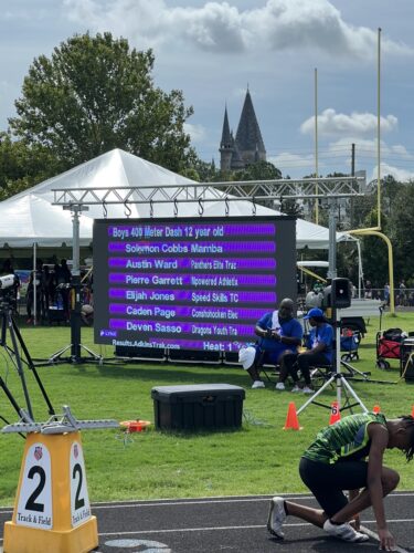 Outdoor track and field meet with athletes preparing for competition.
