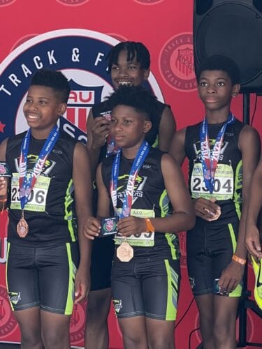 Athletes celebrating with medals at a track event.