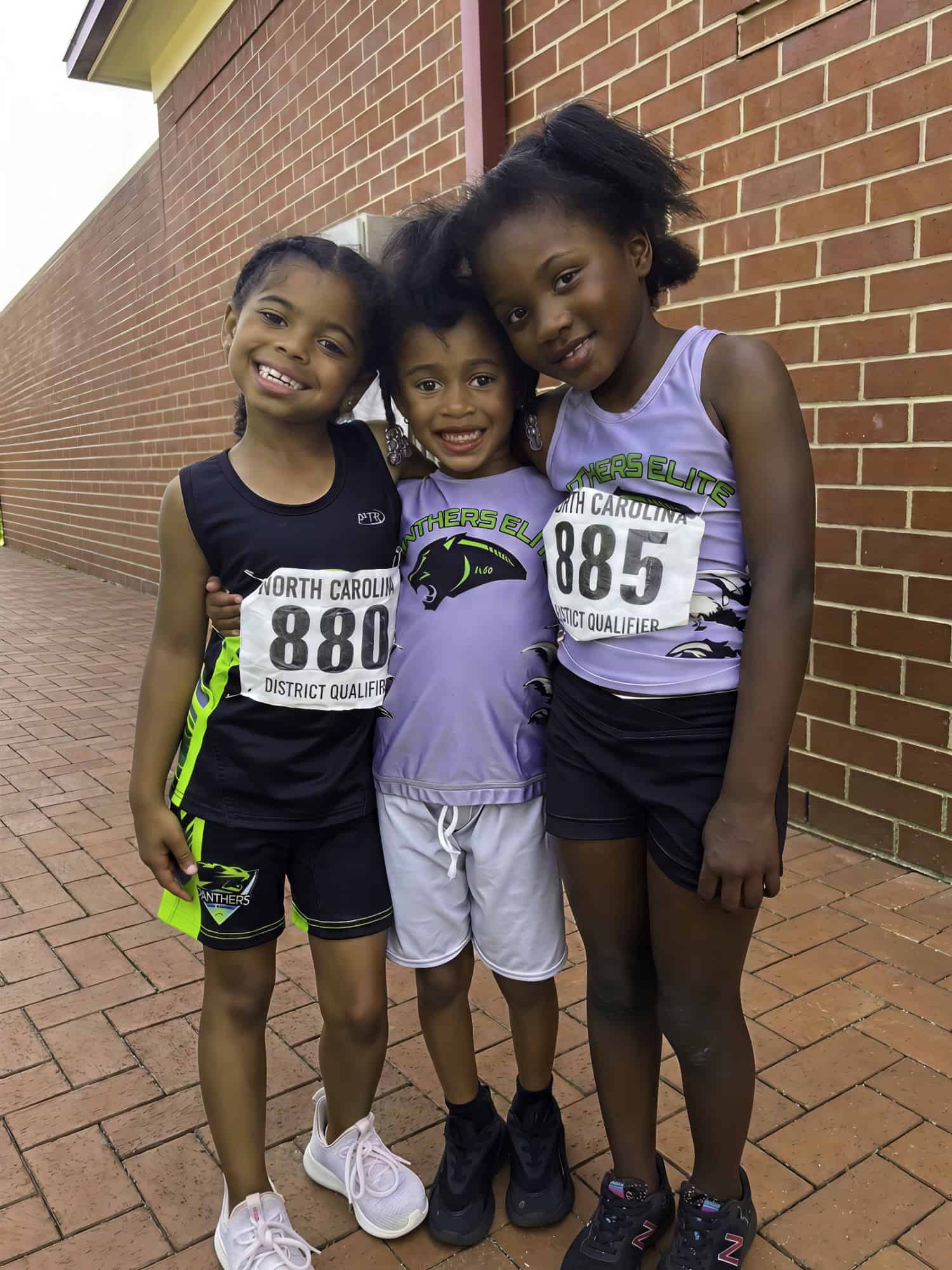 Young female athletes smiling at the track meet.