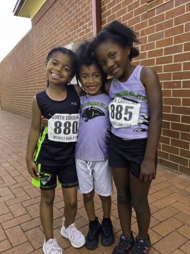 Young female athletes smiling at the track meet.