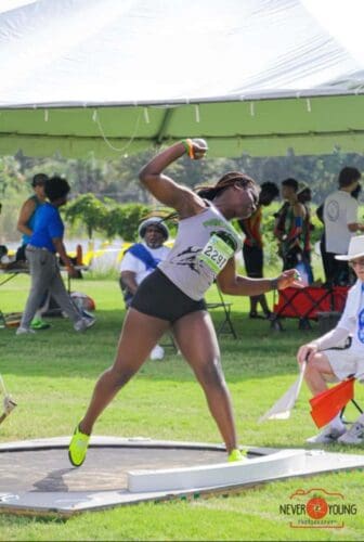 Female athlete in mid-throw at Panthers Elite Track & Field event outdoors.