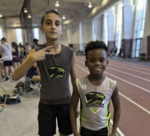 Two young athletes at an indoor track and field facility, representing Panthers Elite Club.