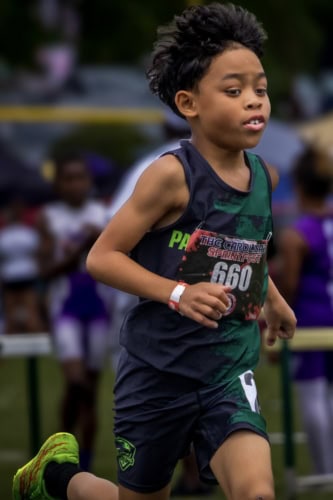 Young boy running in a track race at a Panthers Elite Track & Field event.