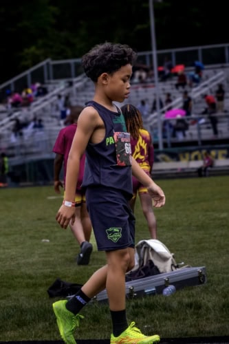 Young athlete in track uniform preparing for a race at the Panthers Elite meet.