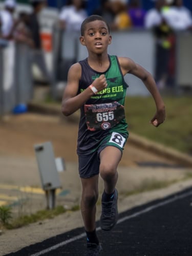 Young athlete sprinting on the track during a competition.
