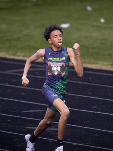Young male athlete sprinting on track during competition.