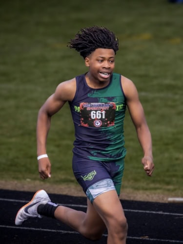 Young male athlete running on track during a race at Panthers Elite Track & Field Club event.