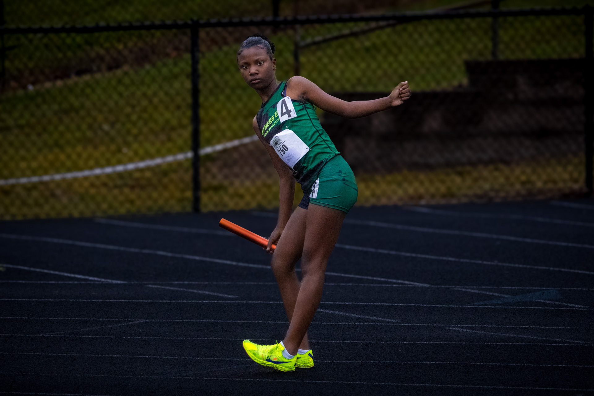 Young female athlete preparing for a relay race on the track.