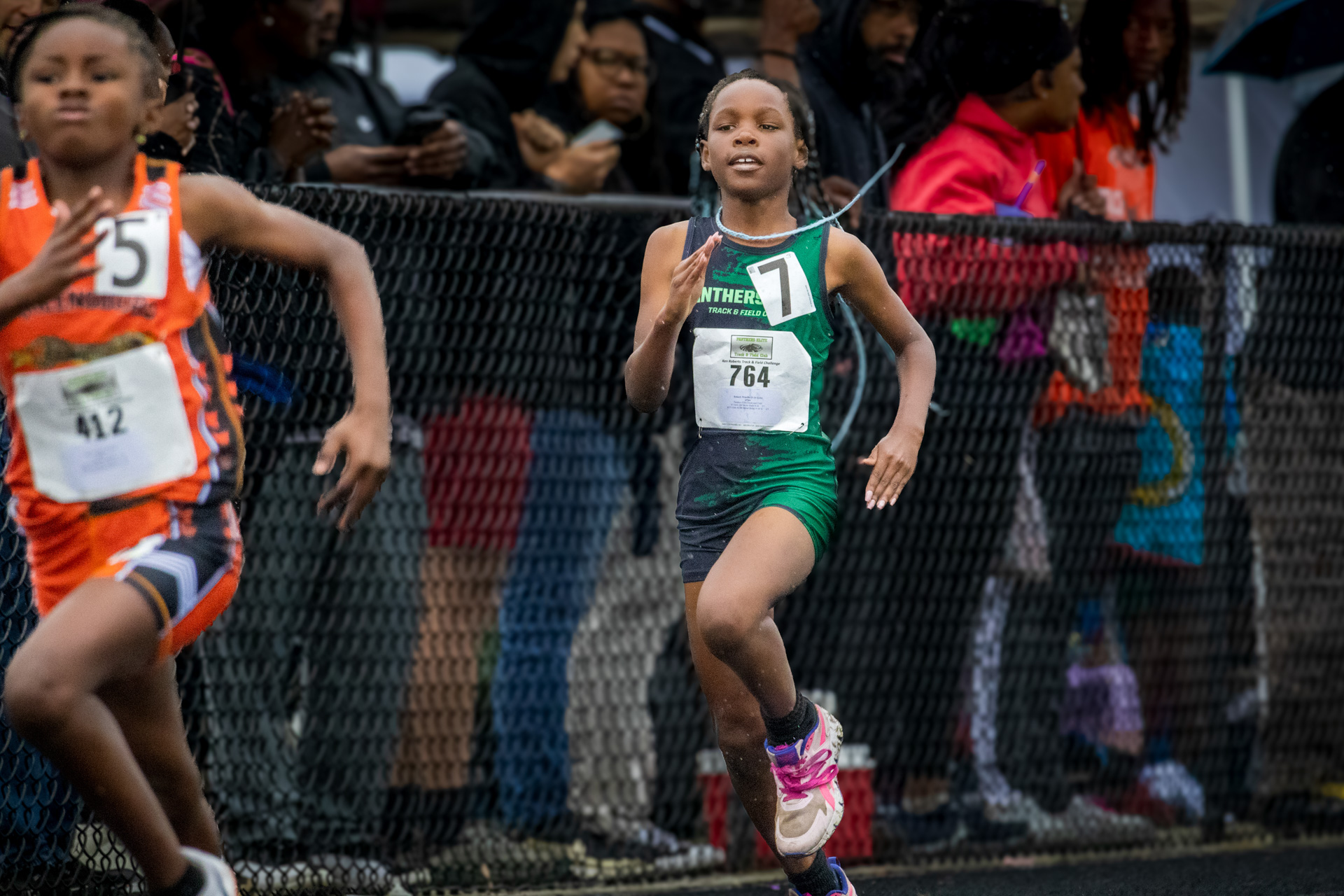 Young female runner competing in a track race at Panthers Elite Track & Field event.