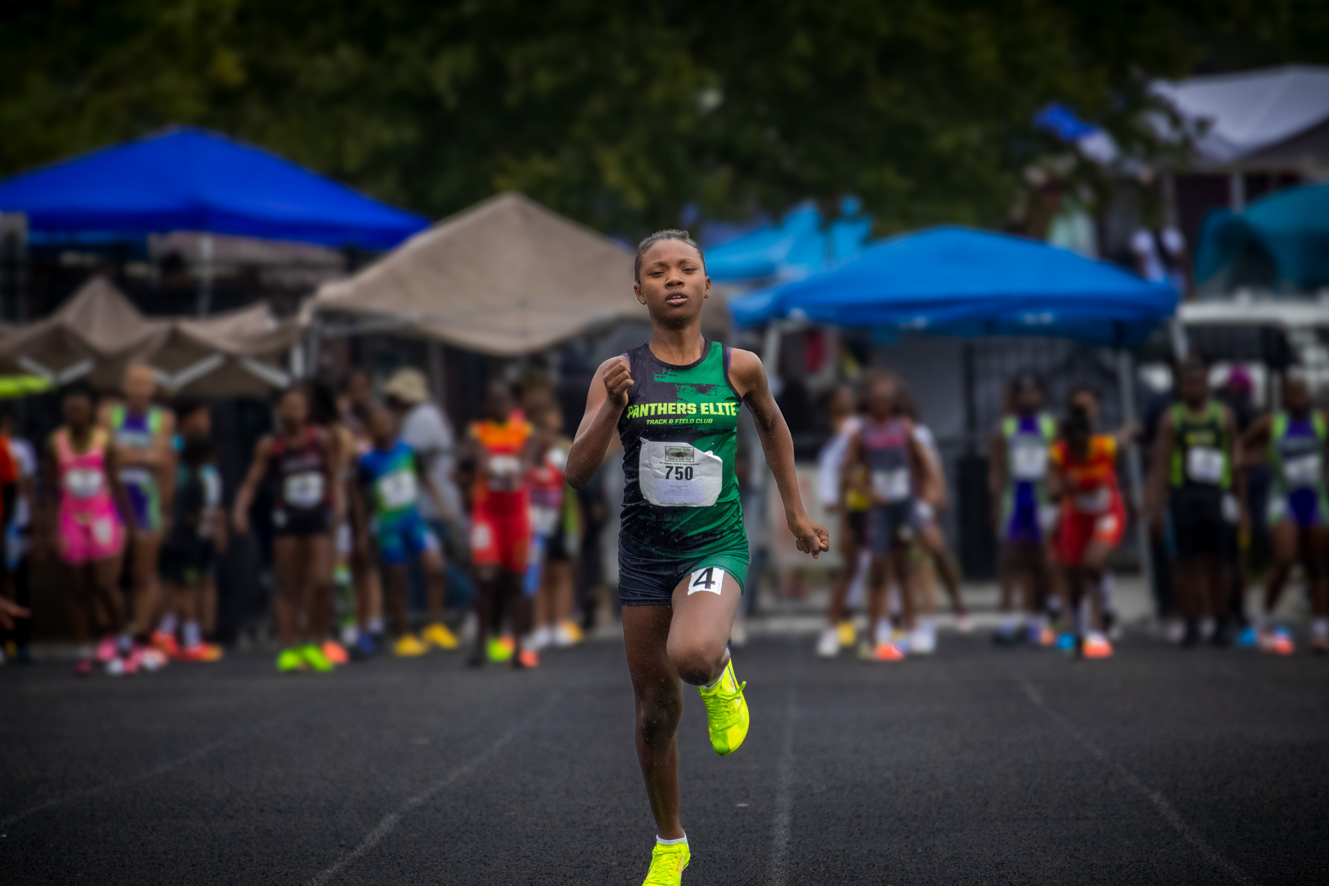 Young male athlete running on track during a Panthers Elite Track & Field event.