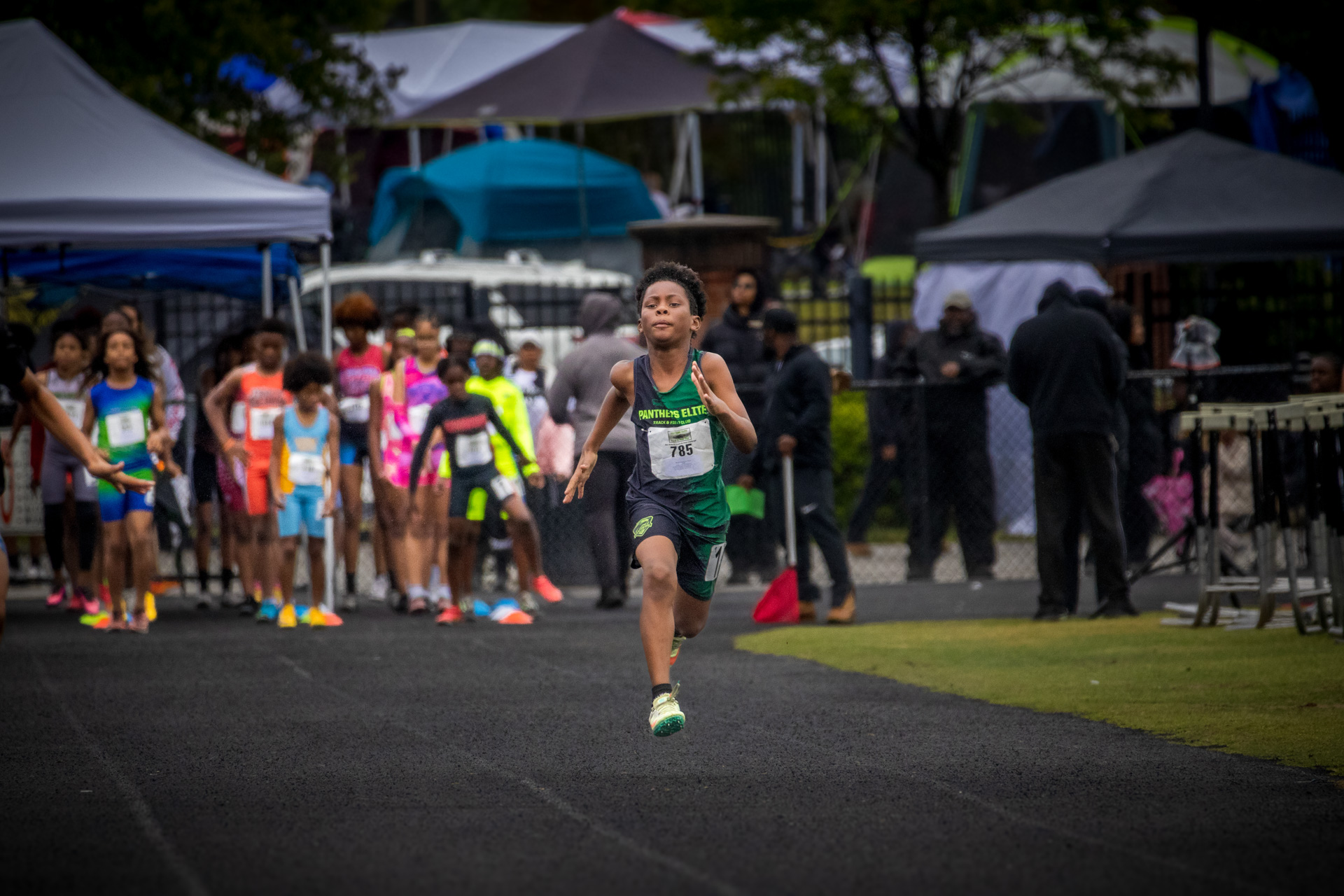 Young male athlete running on track at Panthers Elite Track & Field event.