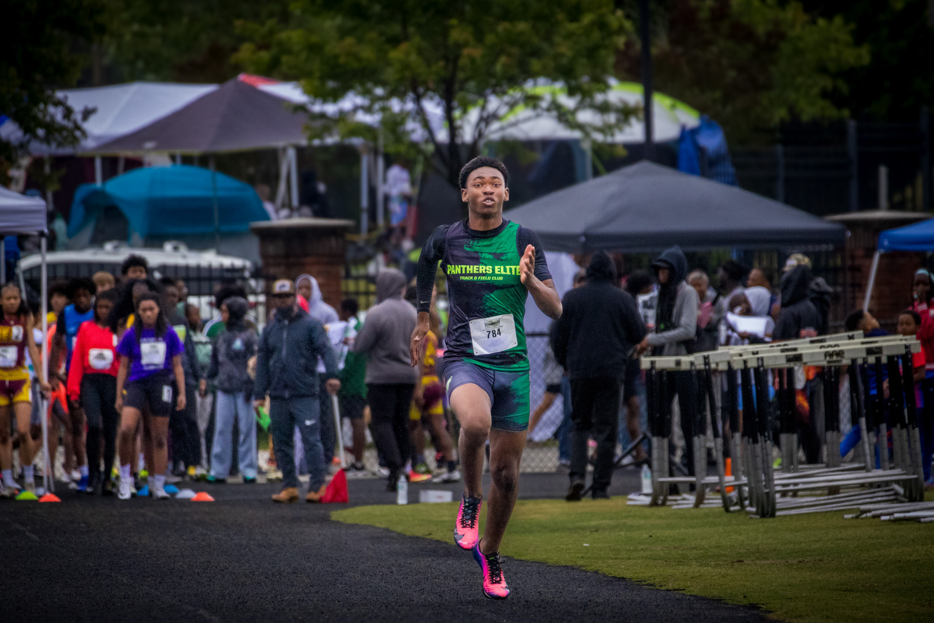 Young male athlete running on track during a Panthers Elite meet.