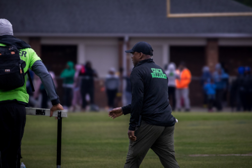 Panthers Elite coach overseeing athletes during a track and field event.